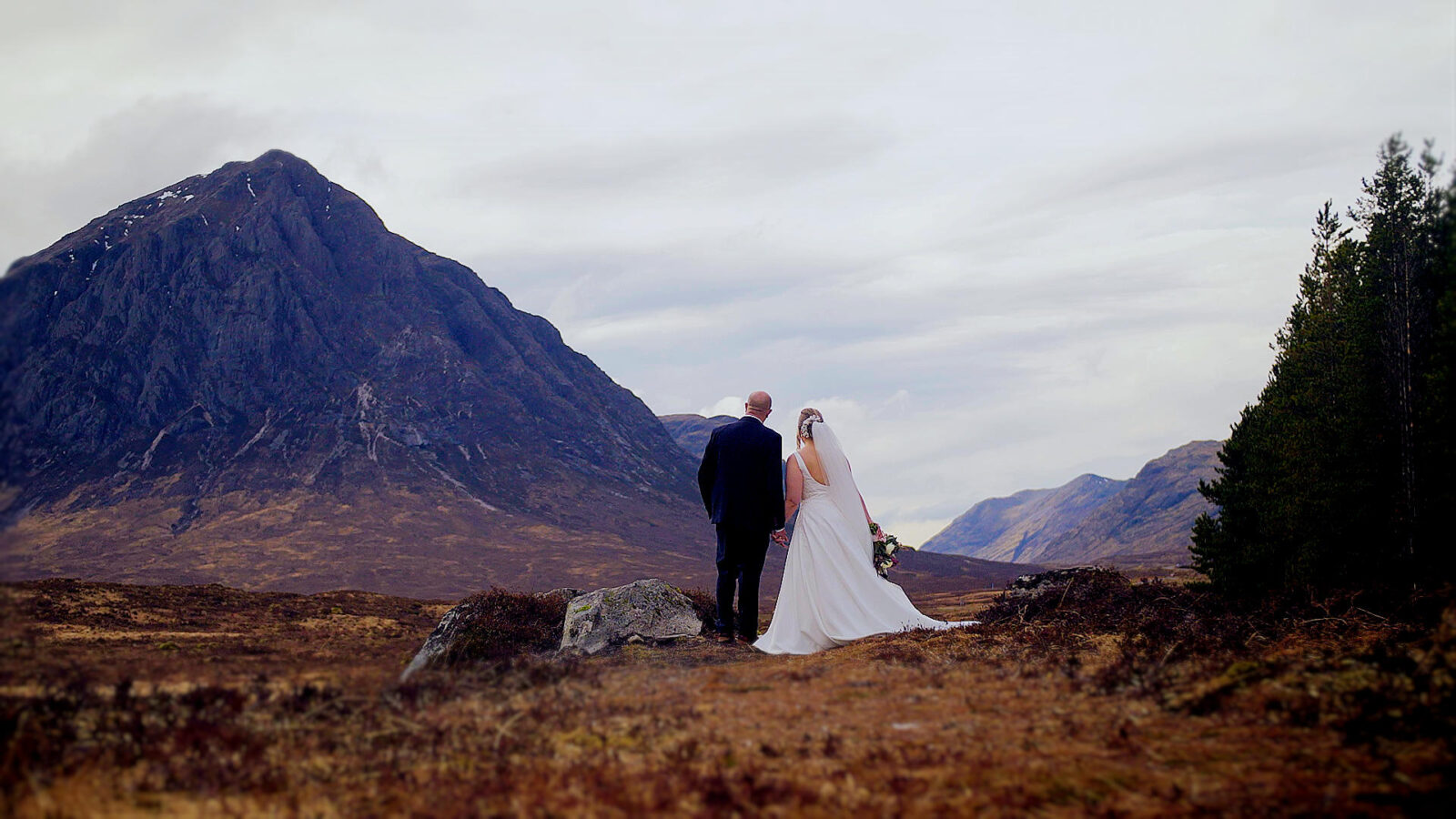 Cinematic elopement film in Scotland of Victoria and Barry at the Kingshouse Hotel, Glencoe, featuring a bagpiper and the dramatic mountains of the Scottish Highlands.